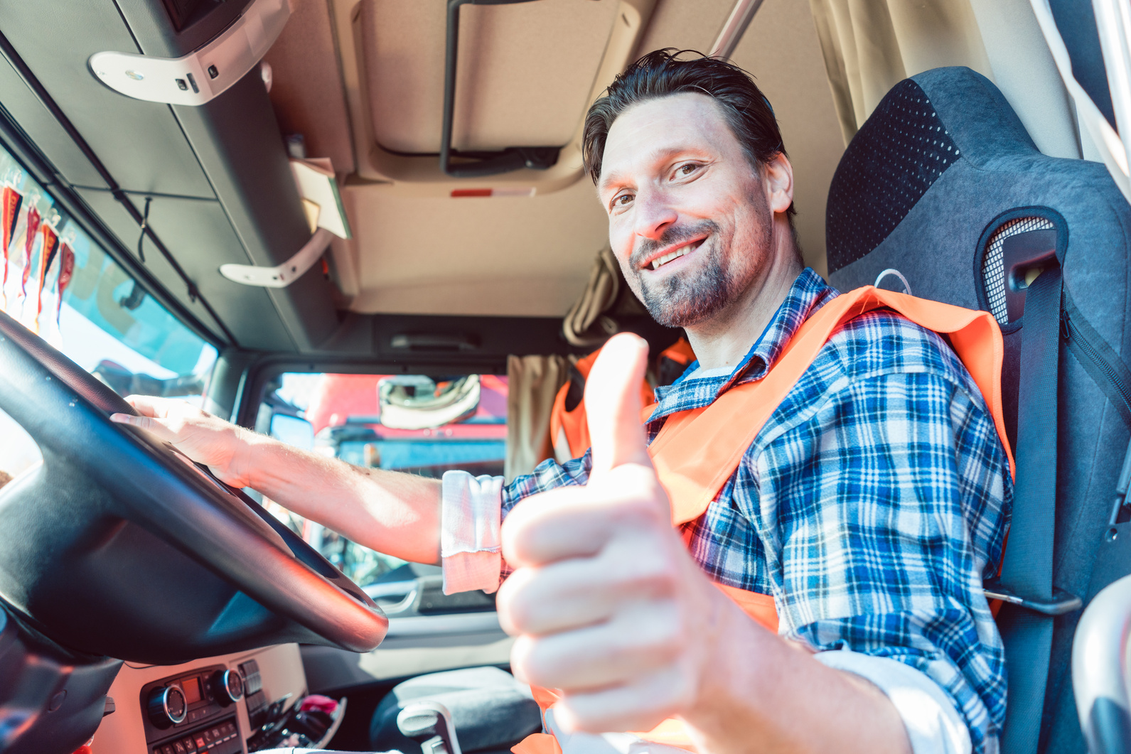 Truck Driver Sitting in Cabin Giving Thumbs up